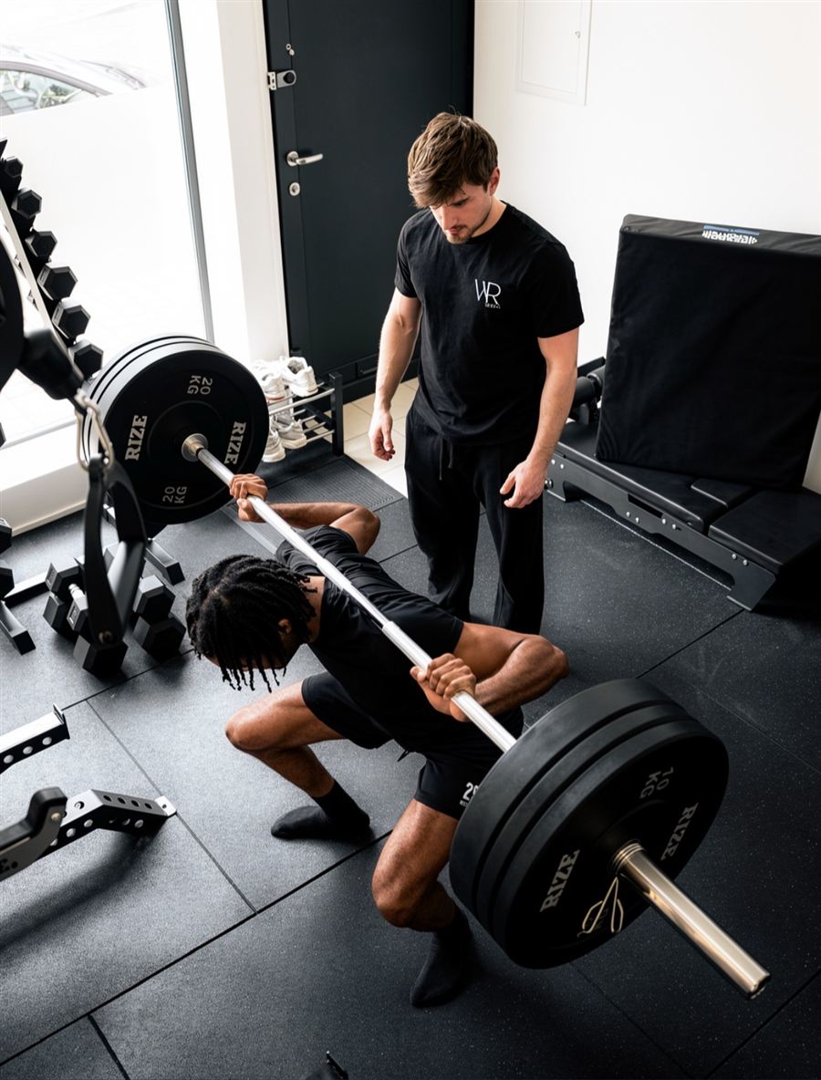 Séance de squat encadrée par un coach au studio